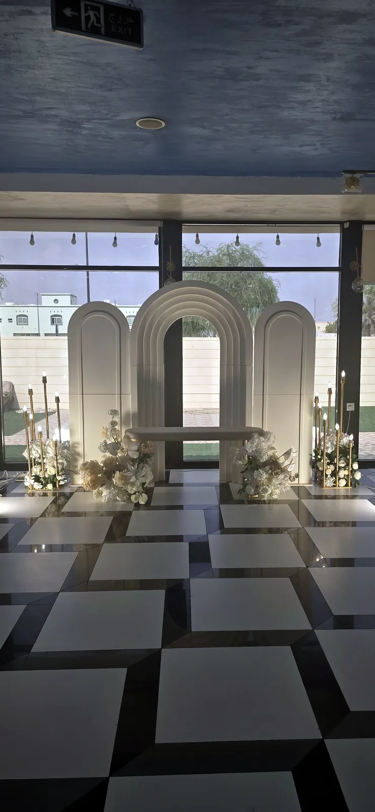 Row of white arches on a black and white checked floor
