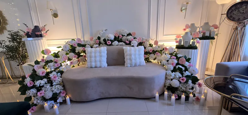 Canapé de velours arrondi encadré de roses roses et blanches et de bougies