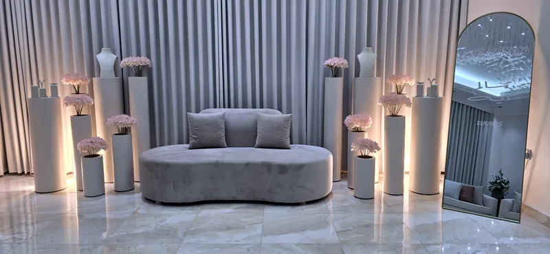 Soft grey lounge with candle pillars and a tall arched mirror