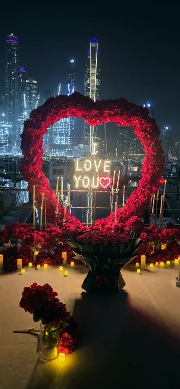 I love you sign inside a rose heart with city towers at night