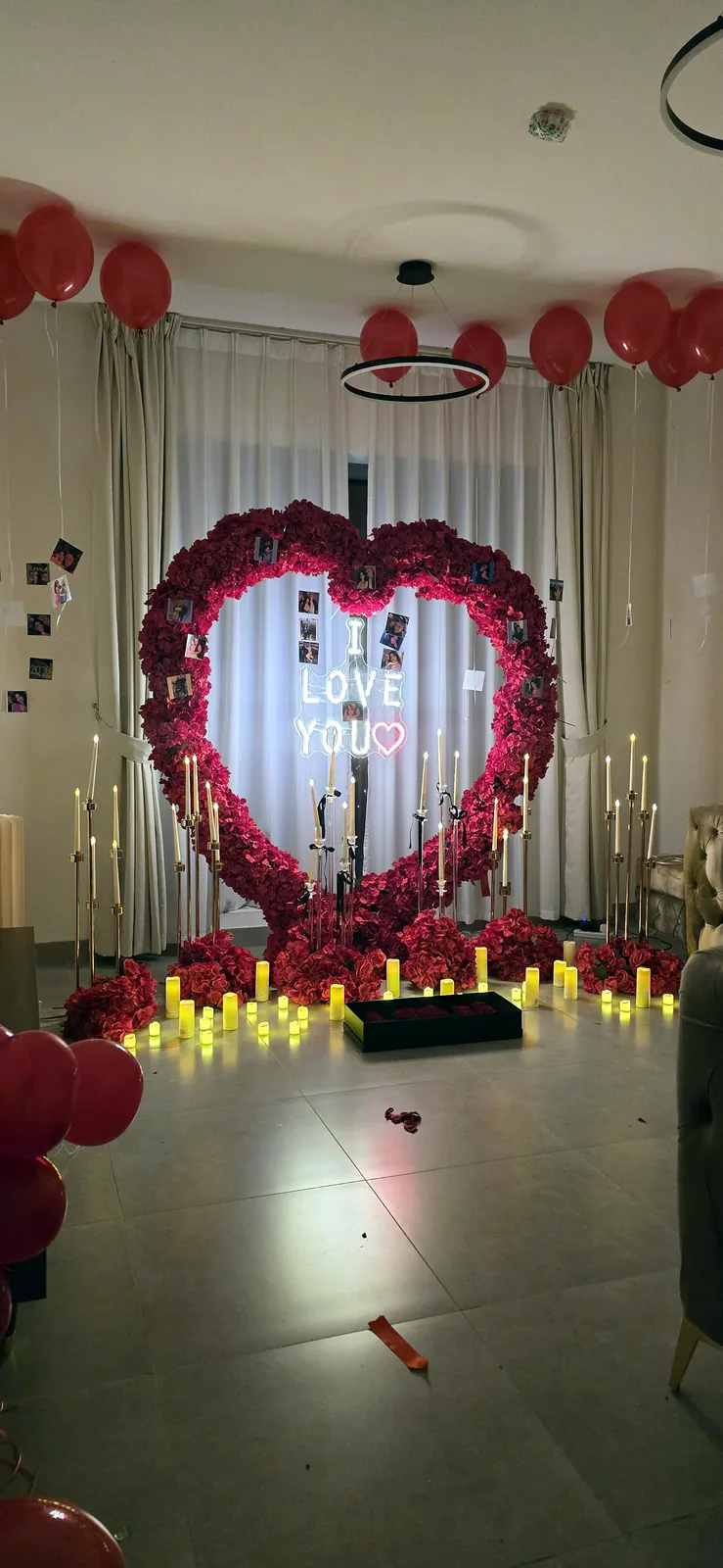 Rose heart with an I love you sign and candles in a room with red balloons
