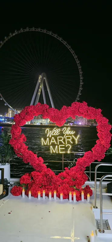Cœur de roses sur un yacht la nuit, grande roue illuminée derrière